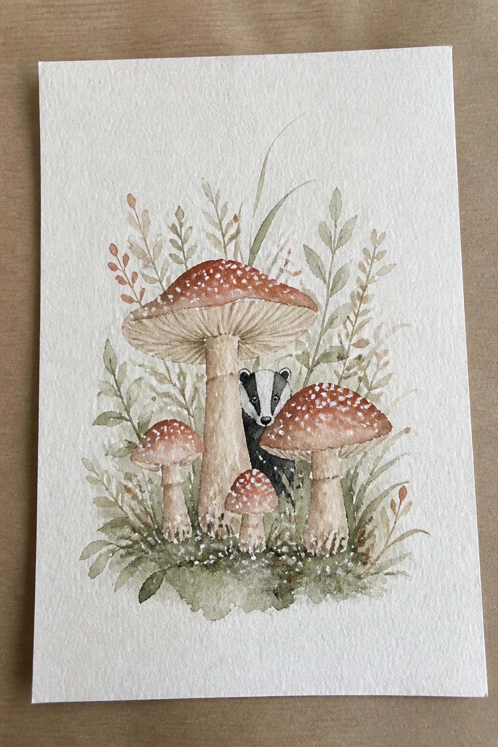 Watercolor painting of spotted mushrooms with a badger peeking from green foliage