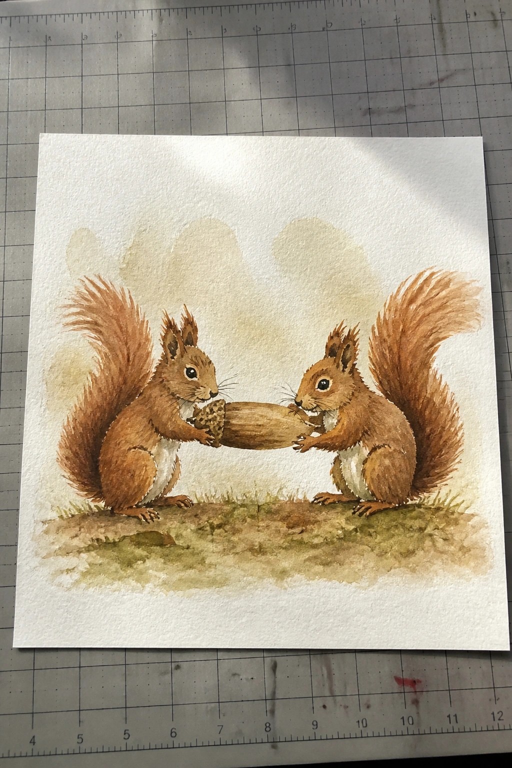 Two brown squirrels holding an acorn together on grassy ground in watercolor