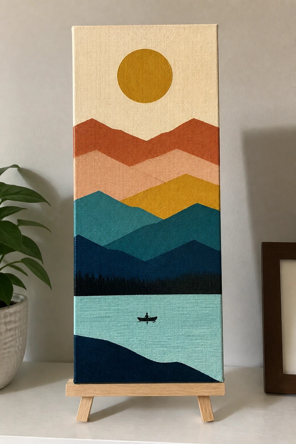 A vertical acrylic painting shows layered mountains in orange, peach, yellow, teal and navy with a yellow sun above and a small boat on light blue water below.