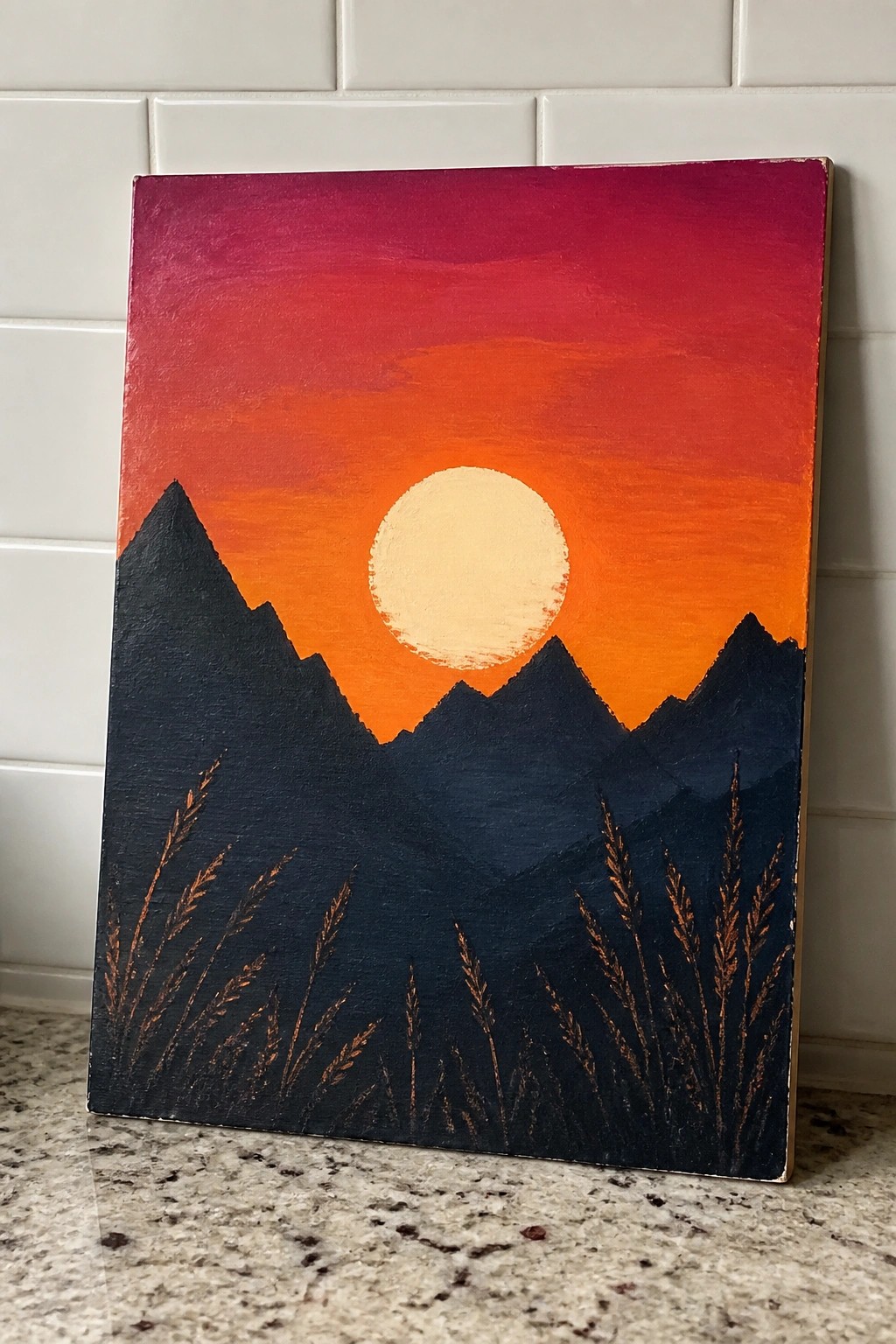 Acrylic painting of orange sunset over dark mountain silhouettes with foreground grass.