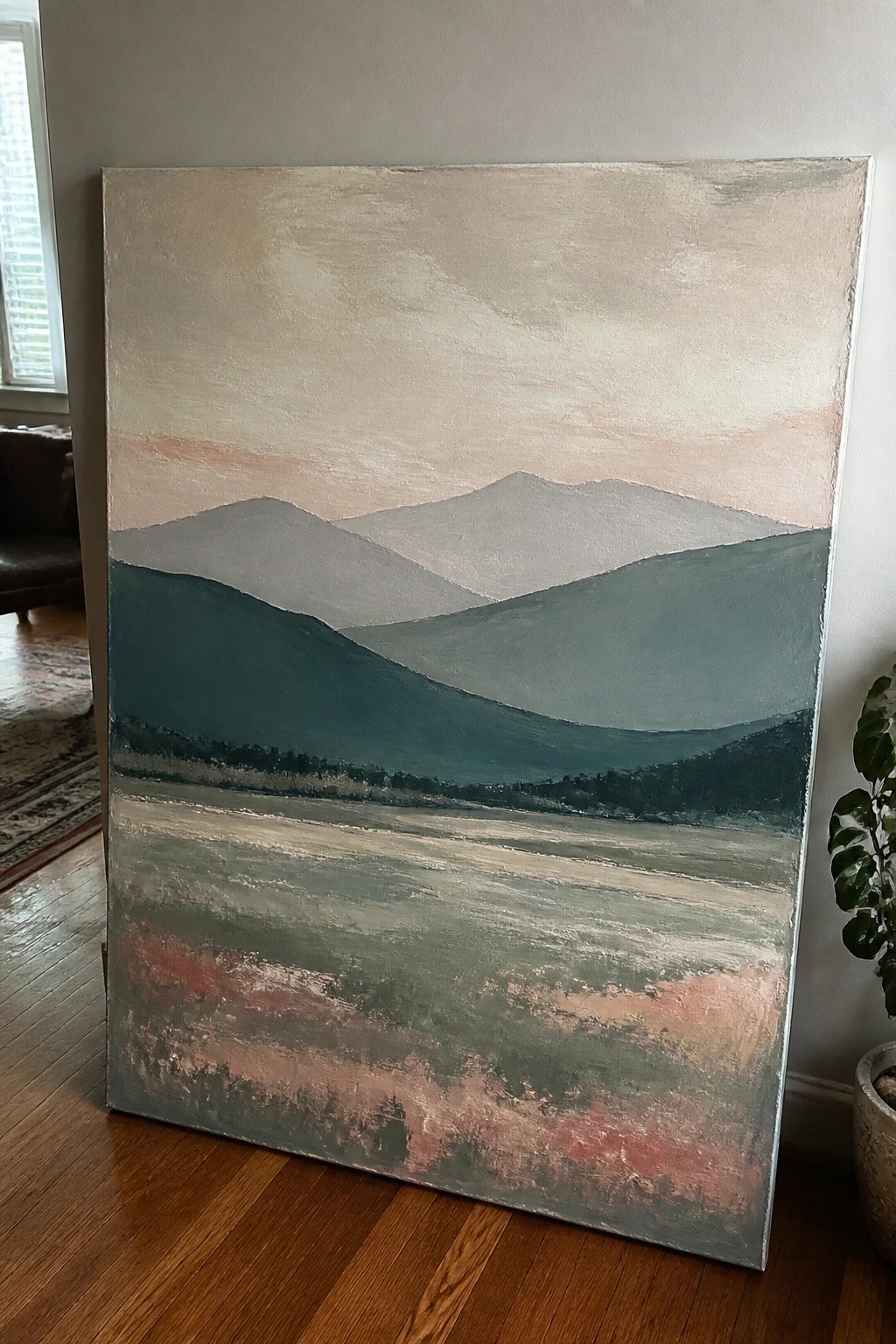 Abstract painting of layered teal mountains with pink sky and textured foreground on floor