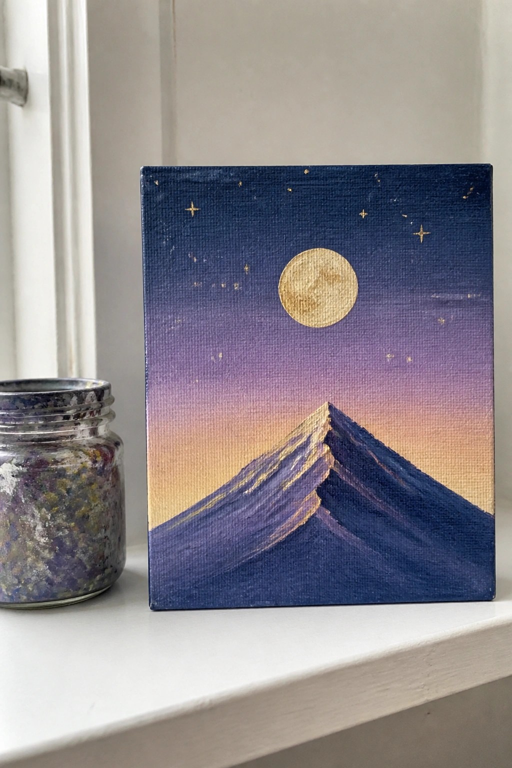 Canvas painting of full moon and stars above dark blue mountains with golden peaks