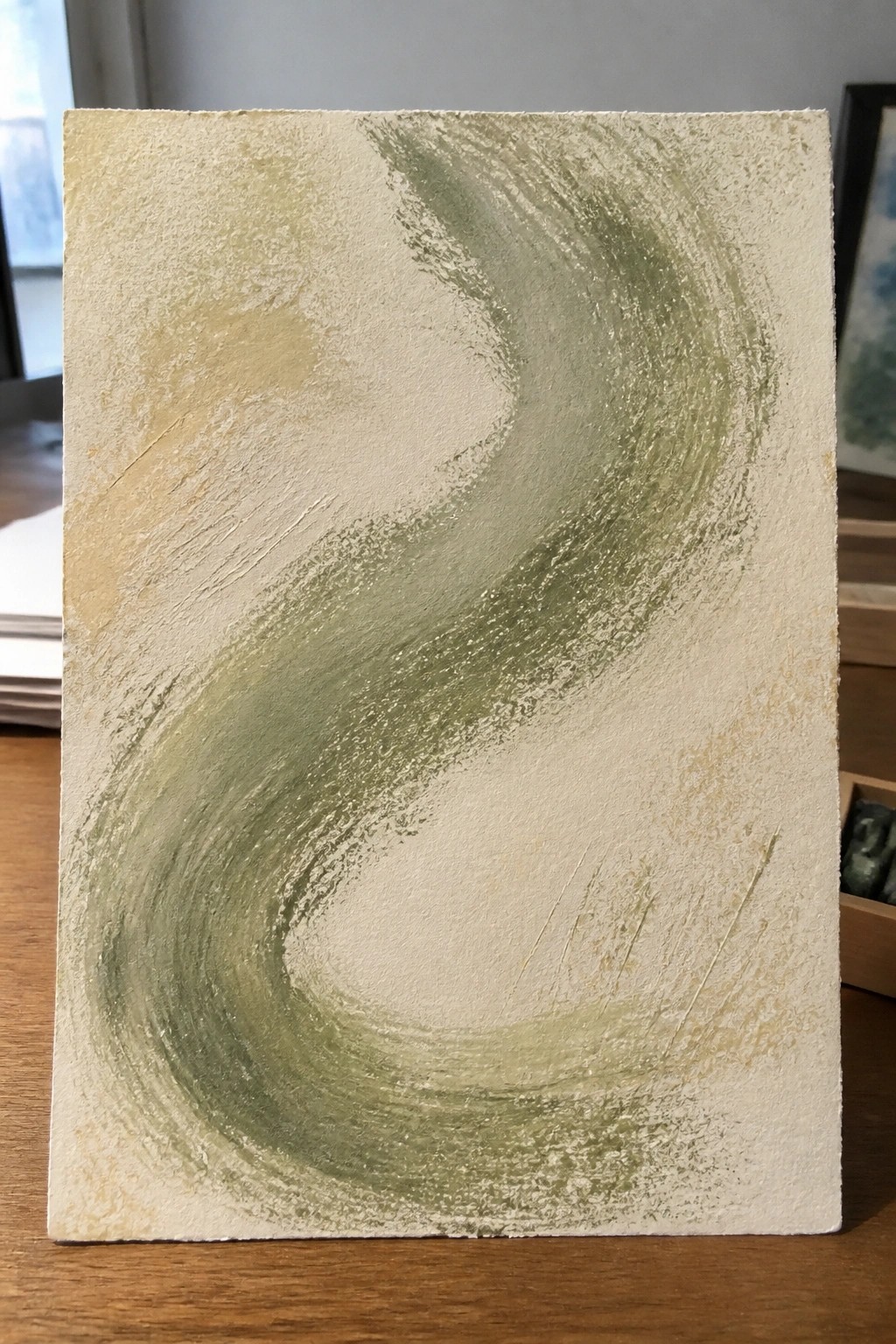 Abstract painting with swirling green brushstrokes on textured off-white canvas on wood.