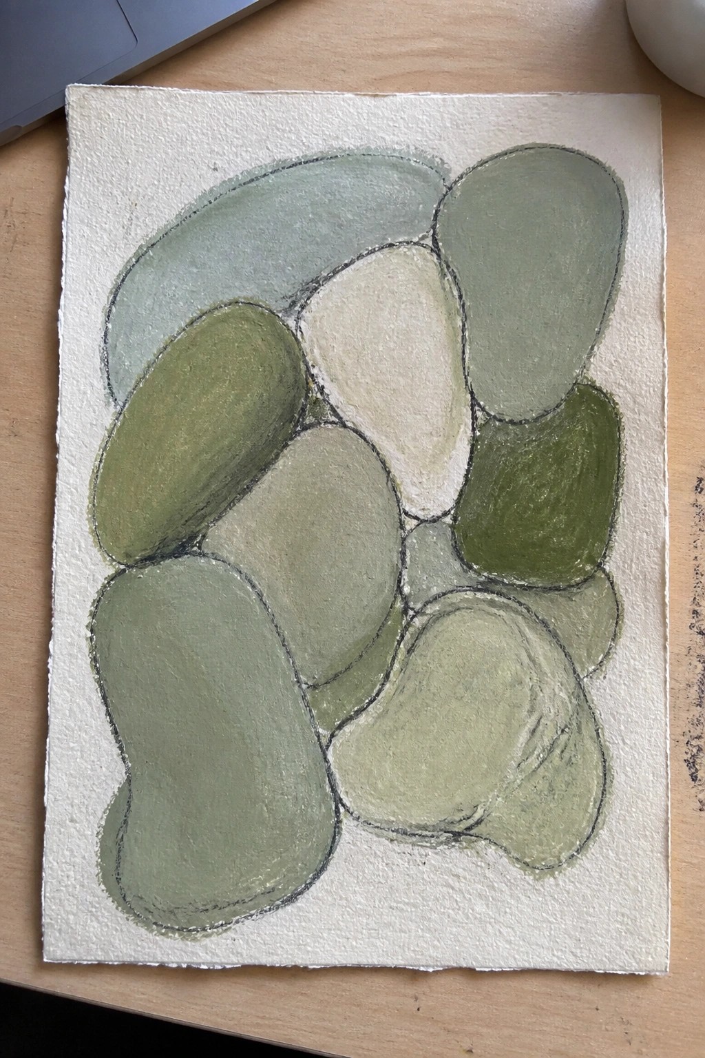 Abstract painting of overlapping rounded shapes in various green shades on white paper.