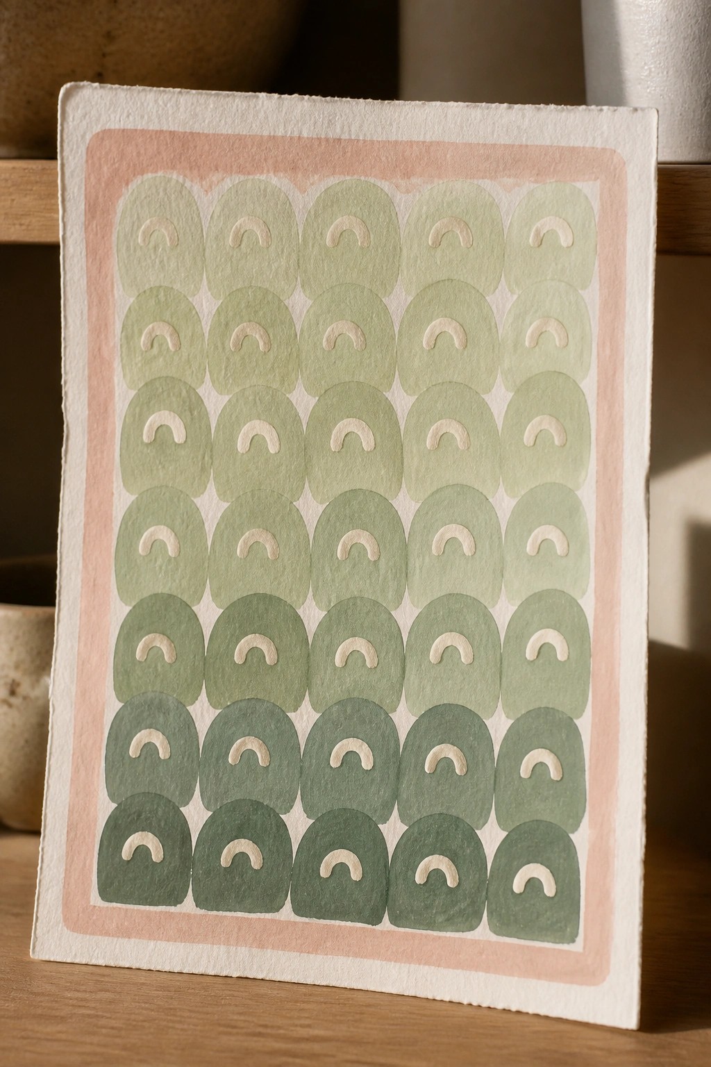 Watercolor print of green arches in rows on pink-bordered paper