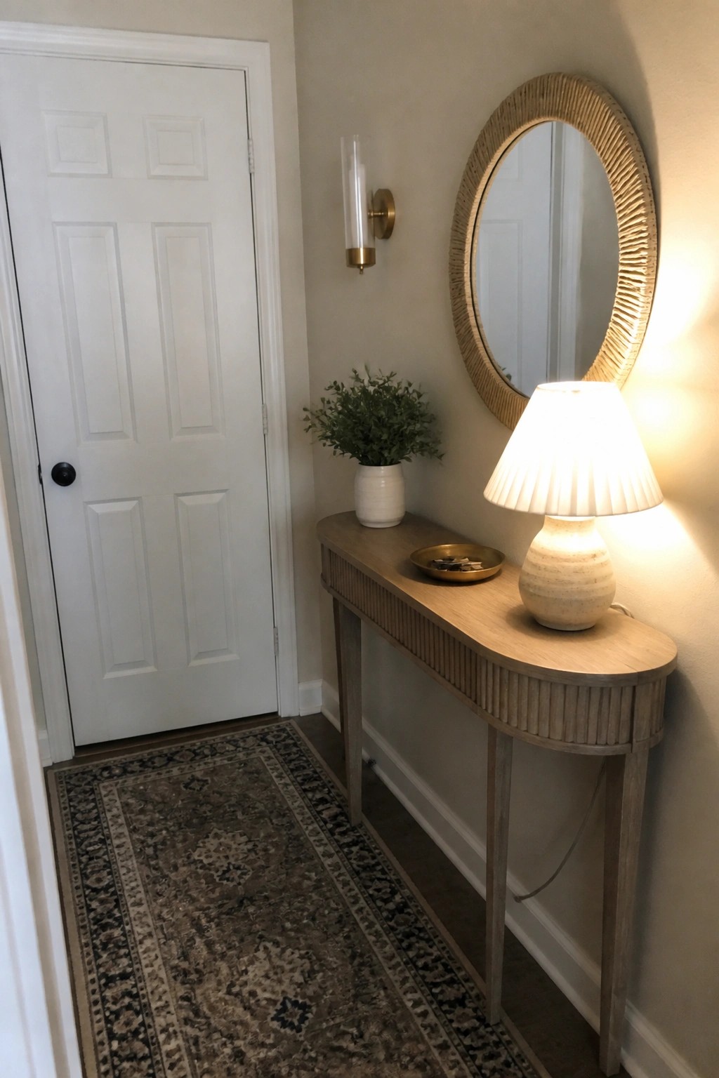 Soft warm beige walls brighten a narrow entryway with a wood console.
