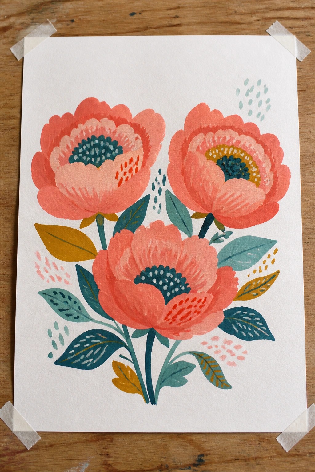 Three coral watercolor flowers with teal centers, leaves on taped paper over wood.