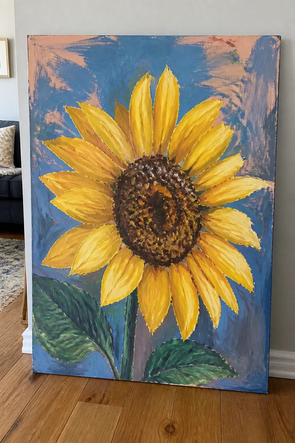 Large vibrant sunflower painting with yellow petals, brown center, green leaves on blue background