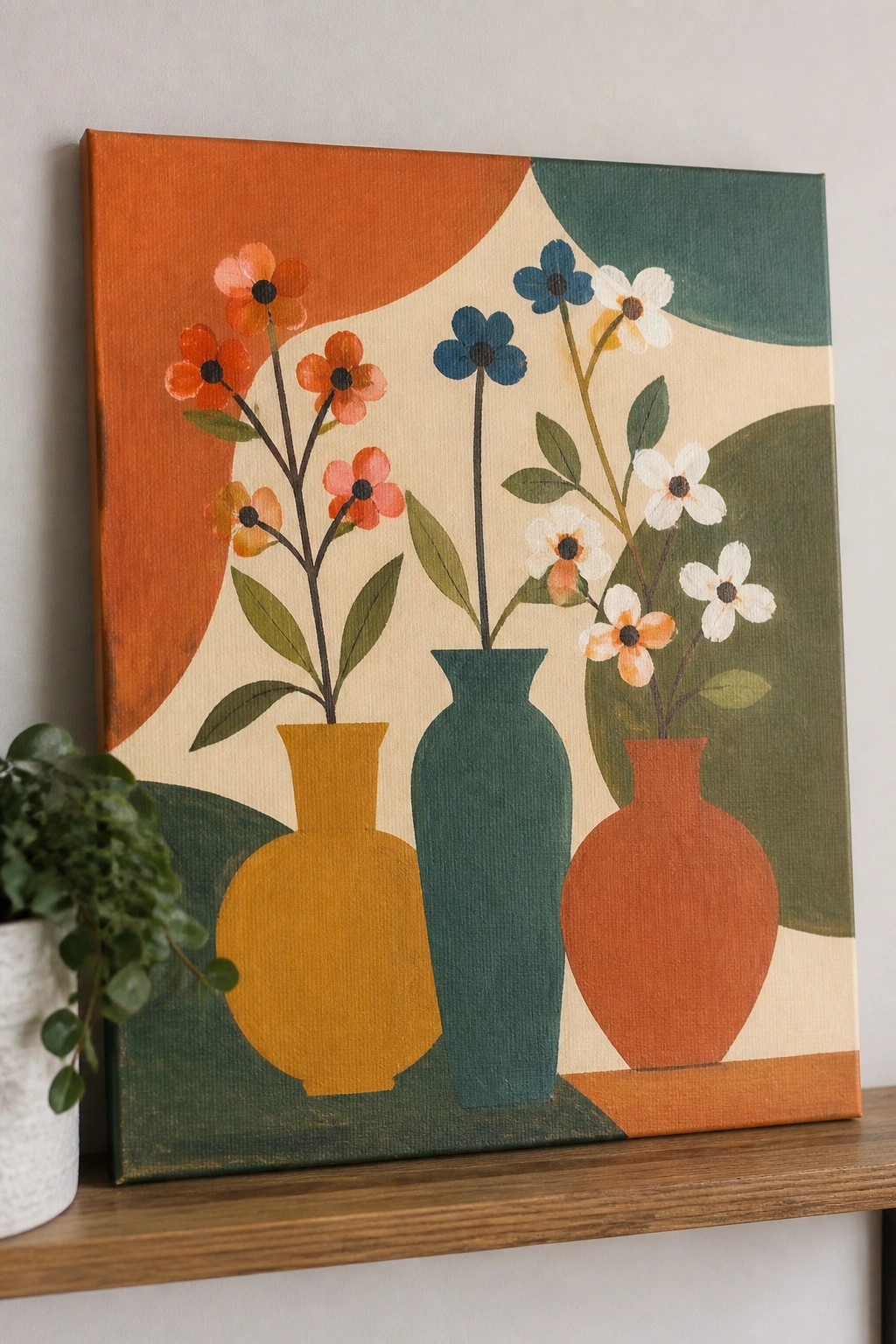 Acrylic painting of three vases with flowers in orange, blue, and white against orange, beige, and green background shapes on a canvas.