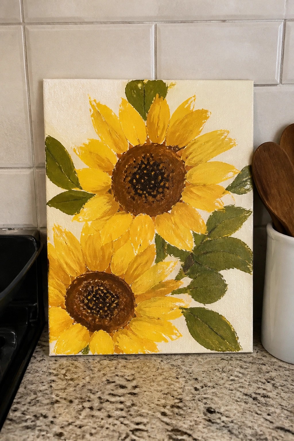 Two yellow sunflowers with brown centers and green leaves on white canvas