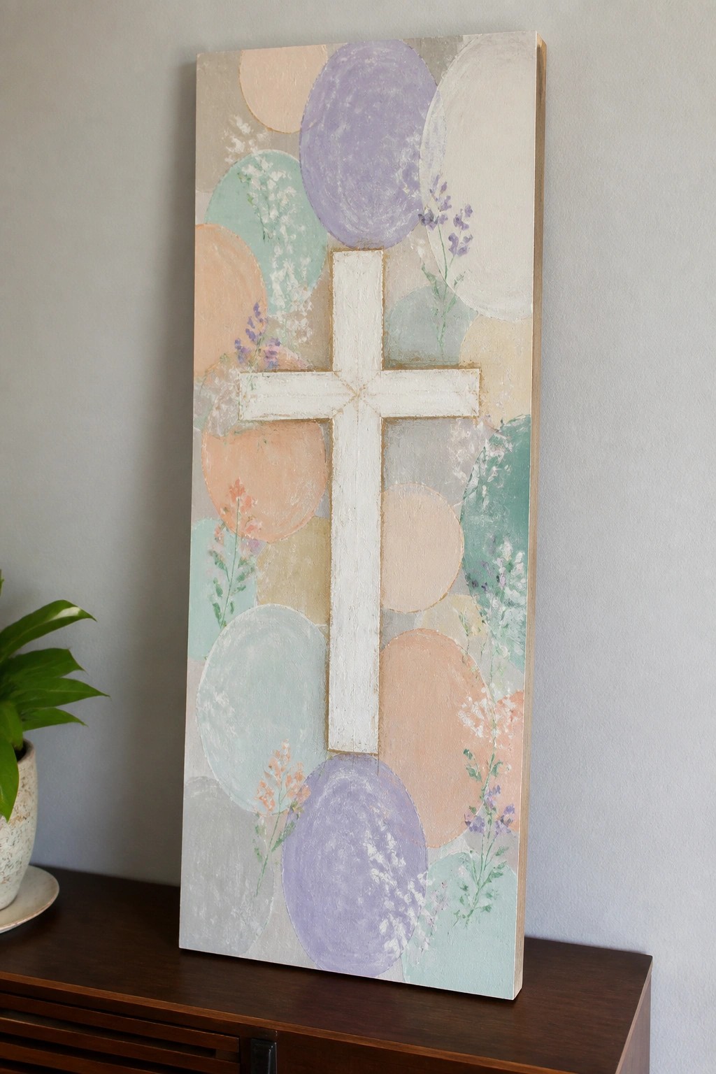 Abstract canvas with white cross amid pastel circles and delicate wildflowers.