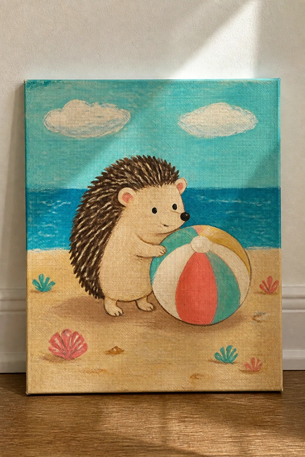 Cute hedgehog on sandy beach touching striped beach ball near ocean and shells
