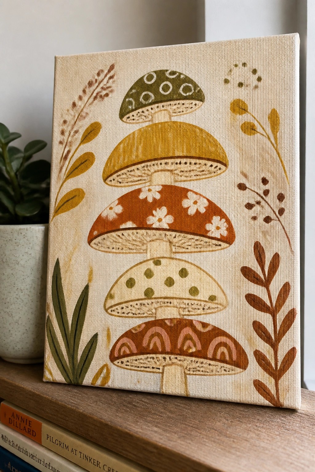 Canvas painting of five stacked patterned mushrooms with botanical leaf accents