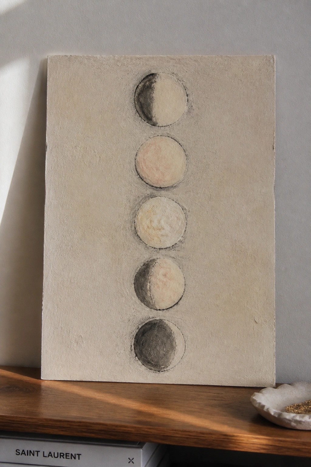 Abstract painting with five vertical moon phase circles on textured beige canvas