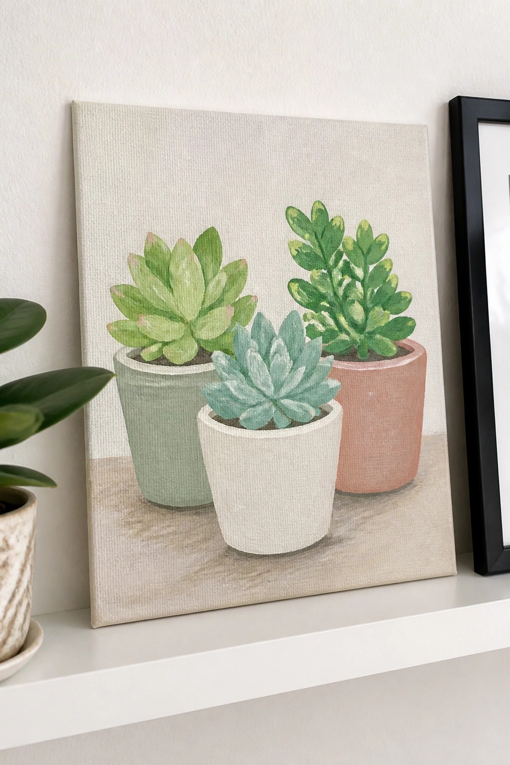 Three succulents in green, white, and pink pots painted on canvas shelf