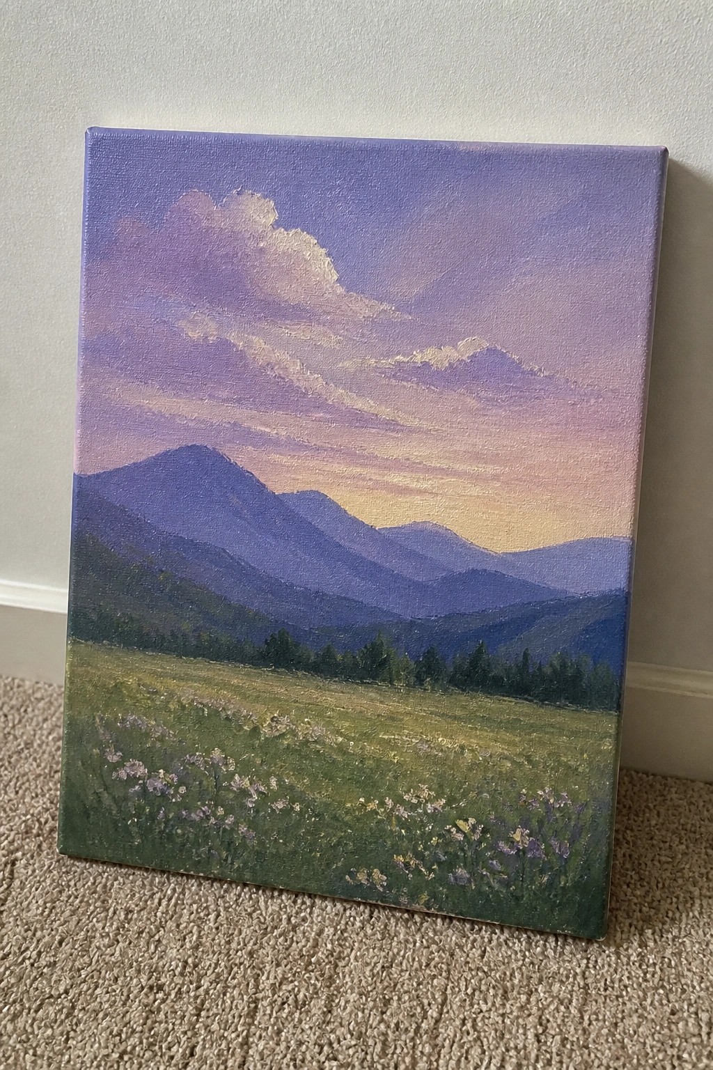 Landscape painting of layered purple mountains at sunset over a wildflower meadow on canvas