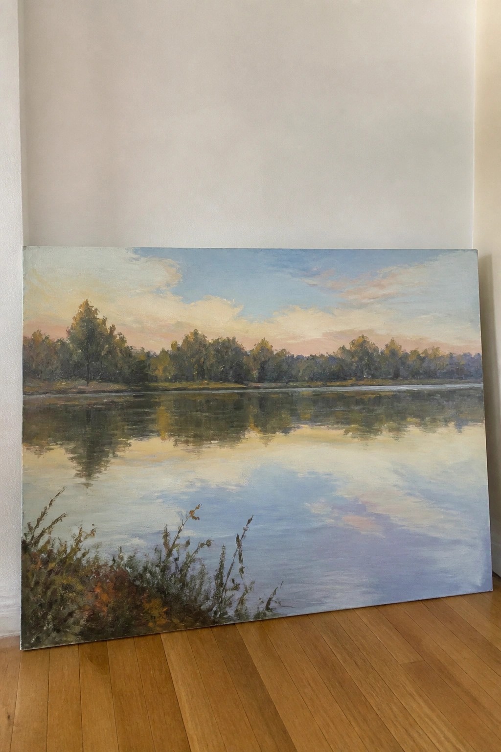 Serene landscape painting of calm lake reflecting pink-blue sky and distant trees.