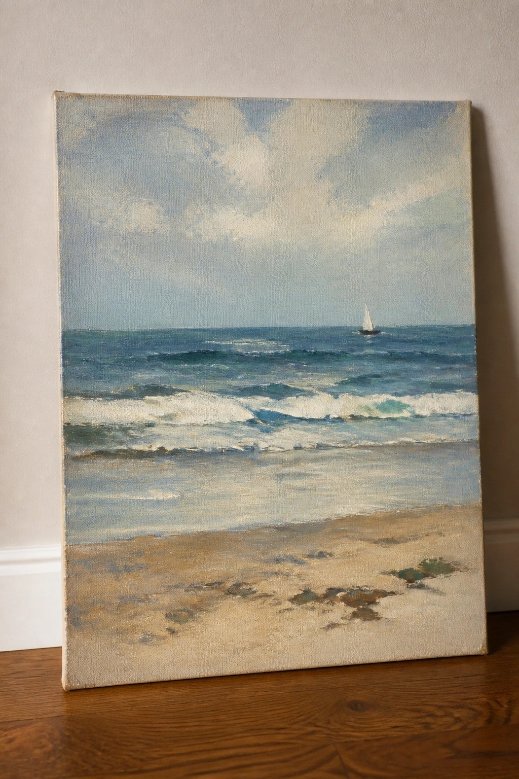 Seascape painting of waves breaking on sandy beach with distant sailboat under cloudy sky