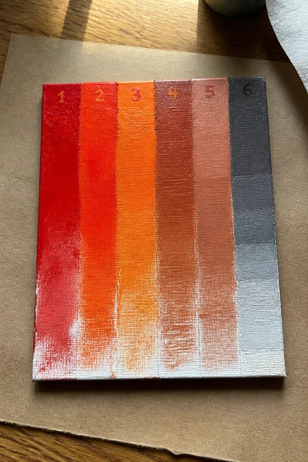 Canvas with vertical stripes of red to gray paint, numbered 1 through 6