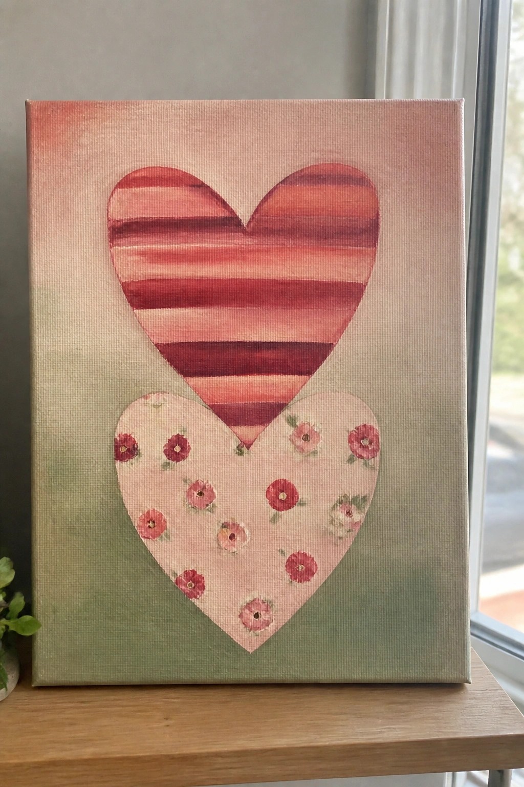 Canvas artwork with striped red heart above floral pink heart on green-pink background.