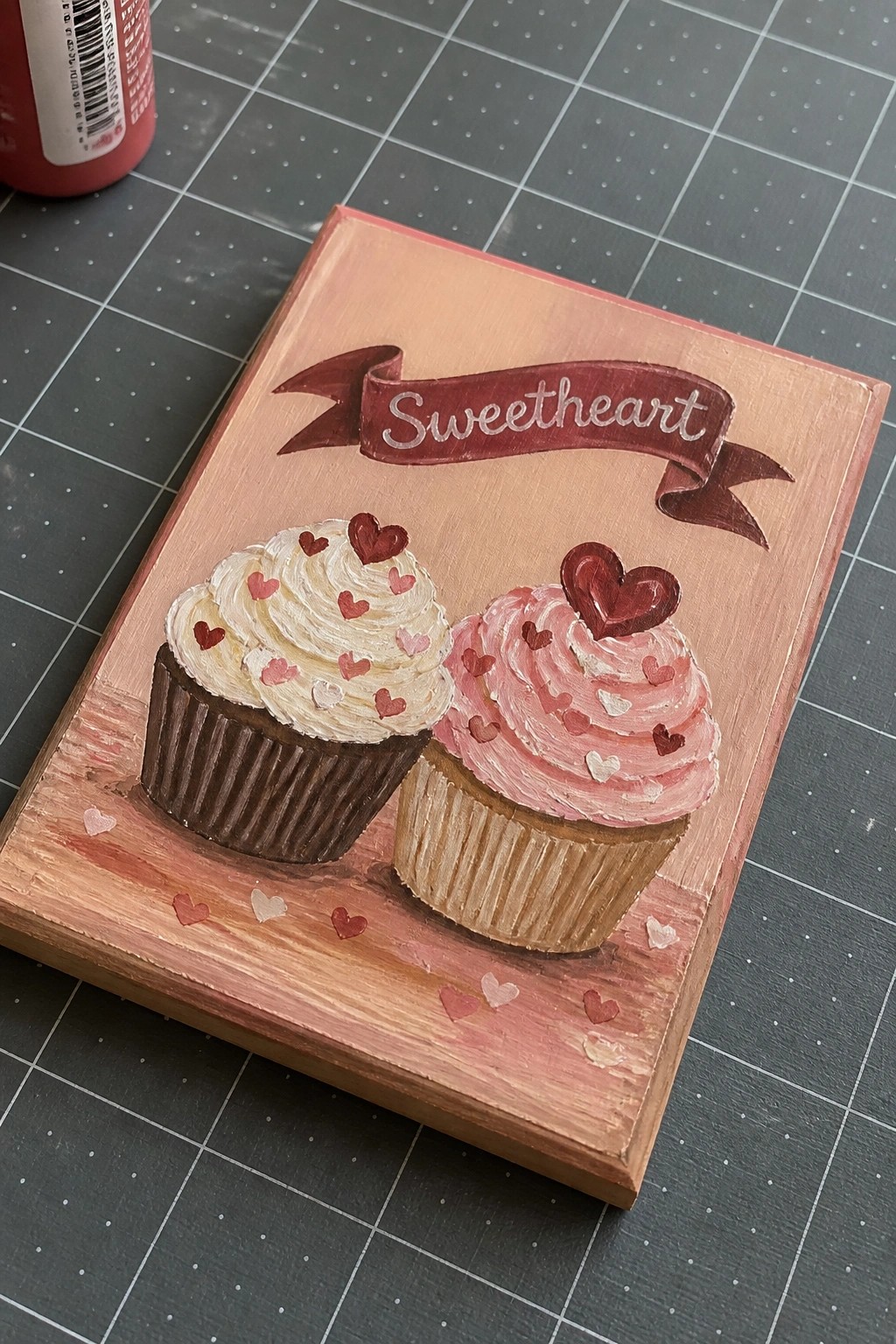 Hand-painted wooden plaque with two heart-topped cupcakes and 
