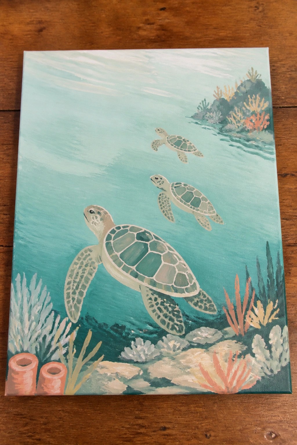 Three sea turtles swimming over coral reefs in turquoise painted waters