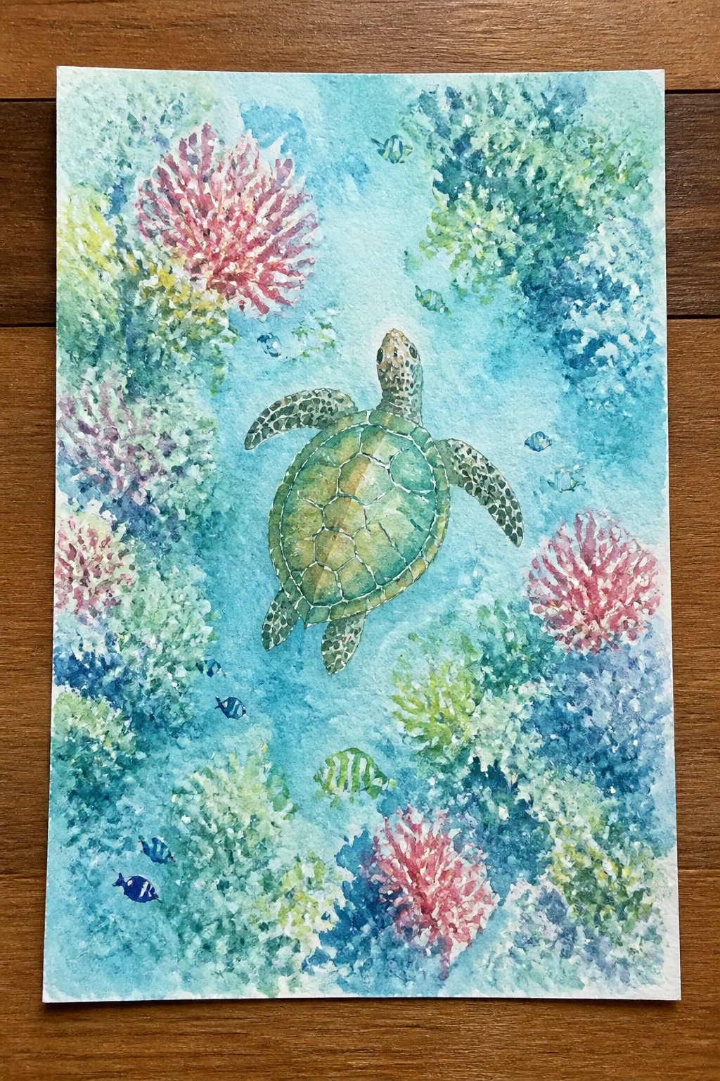 Watercolor painting of green sea turtle amid colorful coral reefs and small fish.