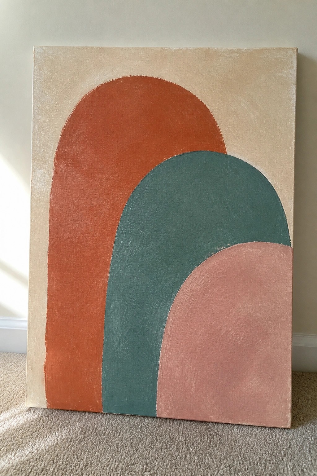 Abstract painting with overlapping arches in orange, teal, and pink on beige background