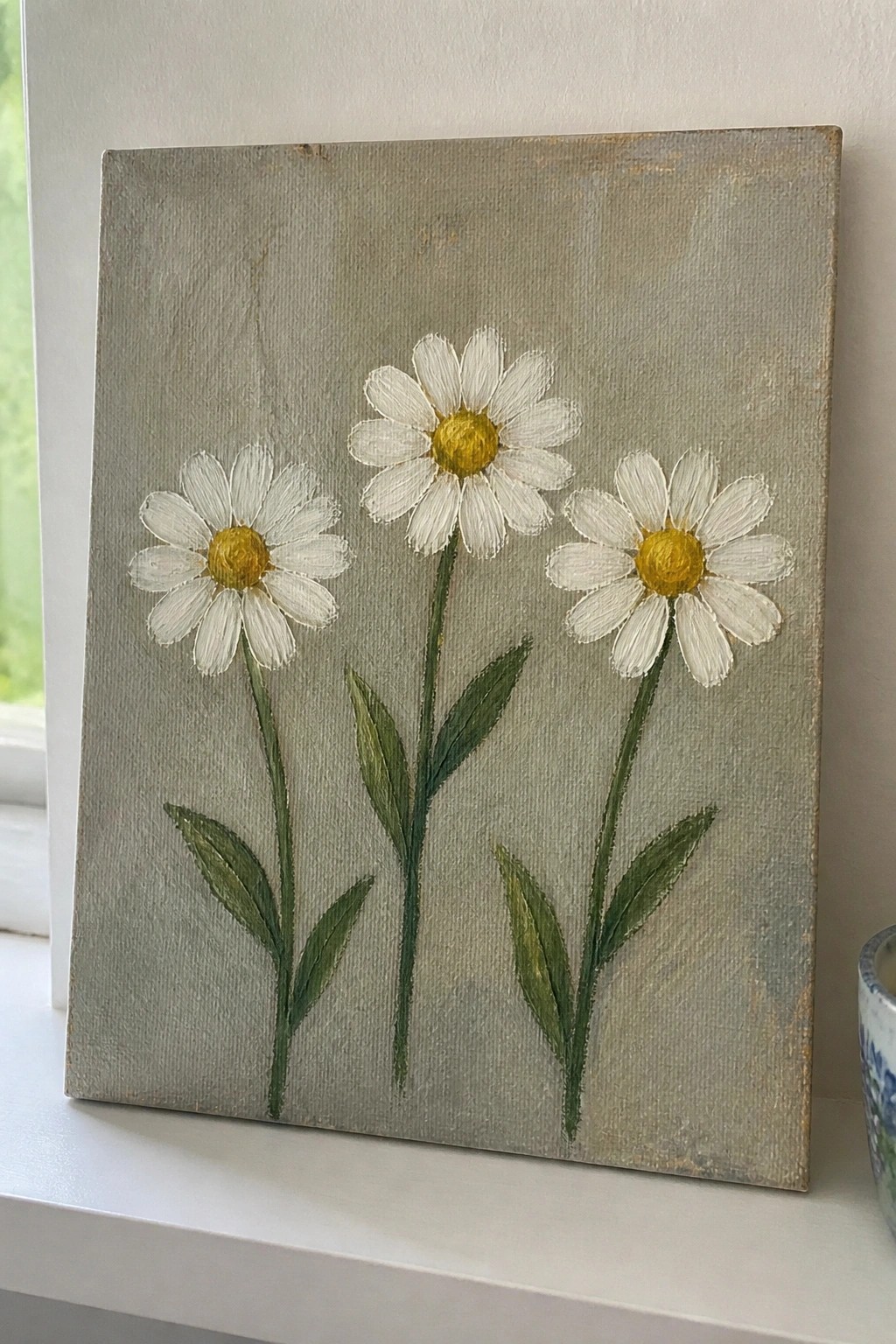 An oil painting of three white daisies with yellow centers on green stems against a gray background.