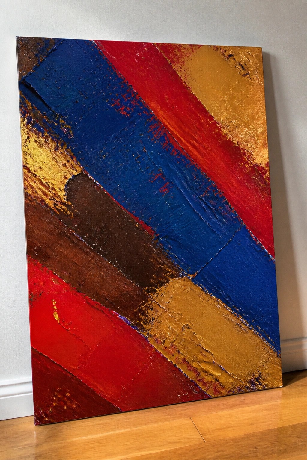Abstract painting with thick textured red, blue, gold, and brown diagonal strokes on floor
