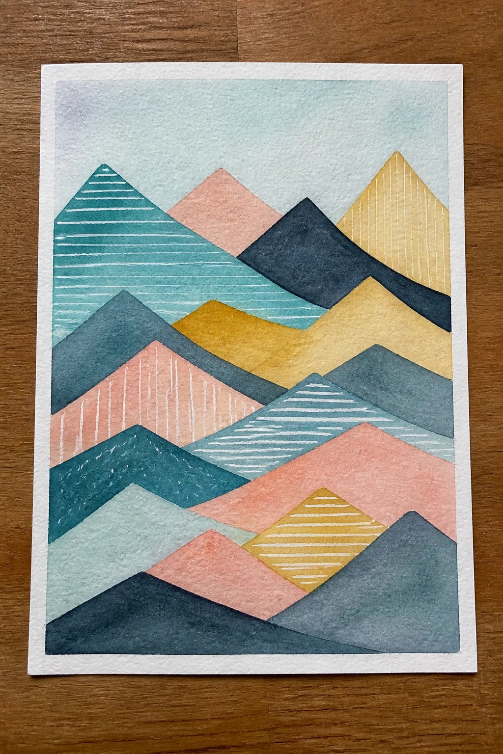 Abstract watercolor of layered geometric mountains in teal, coral, yellow, and navy.