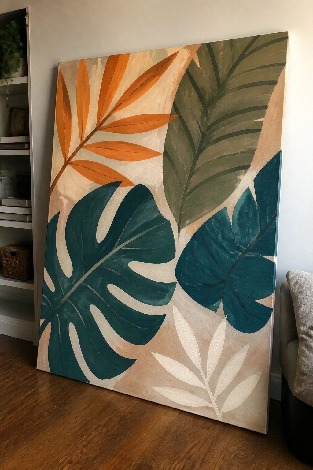 Large canvas painting of tropical leaves in teal, orange, and green.