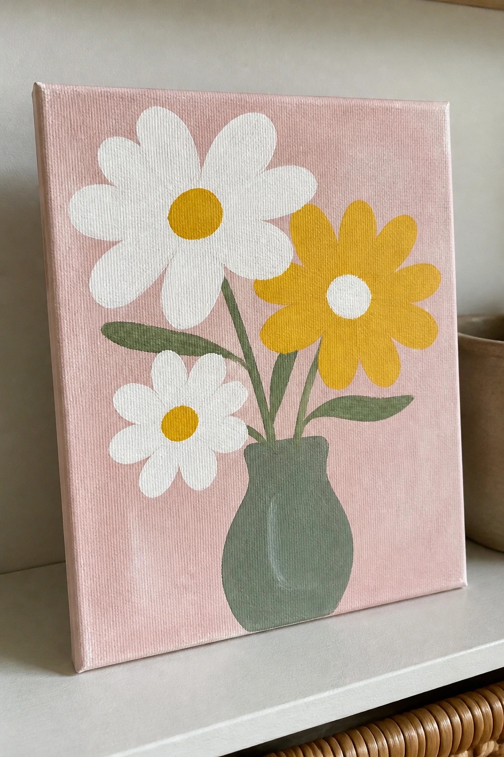 Painting of three daisies in a green vase against a pink background