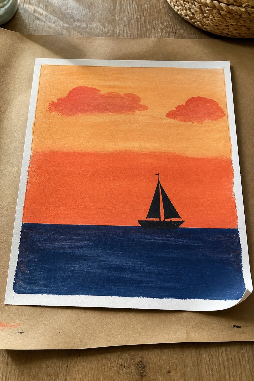 Watercolor seascape of orange-red sunset sky with clouds and black sailboat on blue water