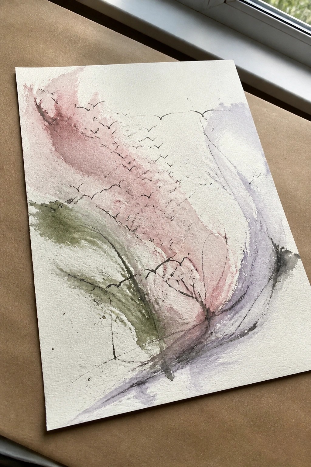 Abstract watercolor with soft pink, purple, and green washes plus black bird-like lines on paper