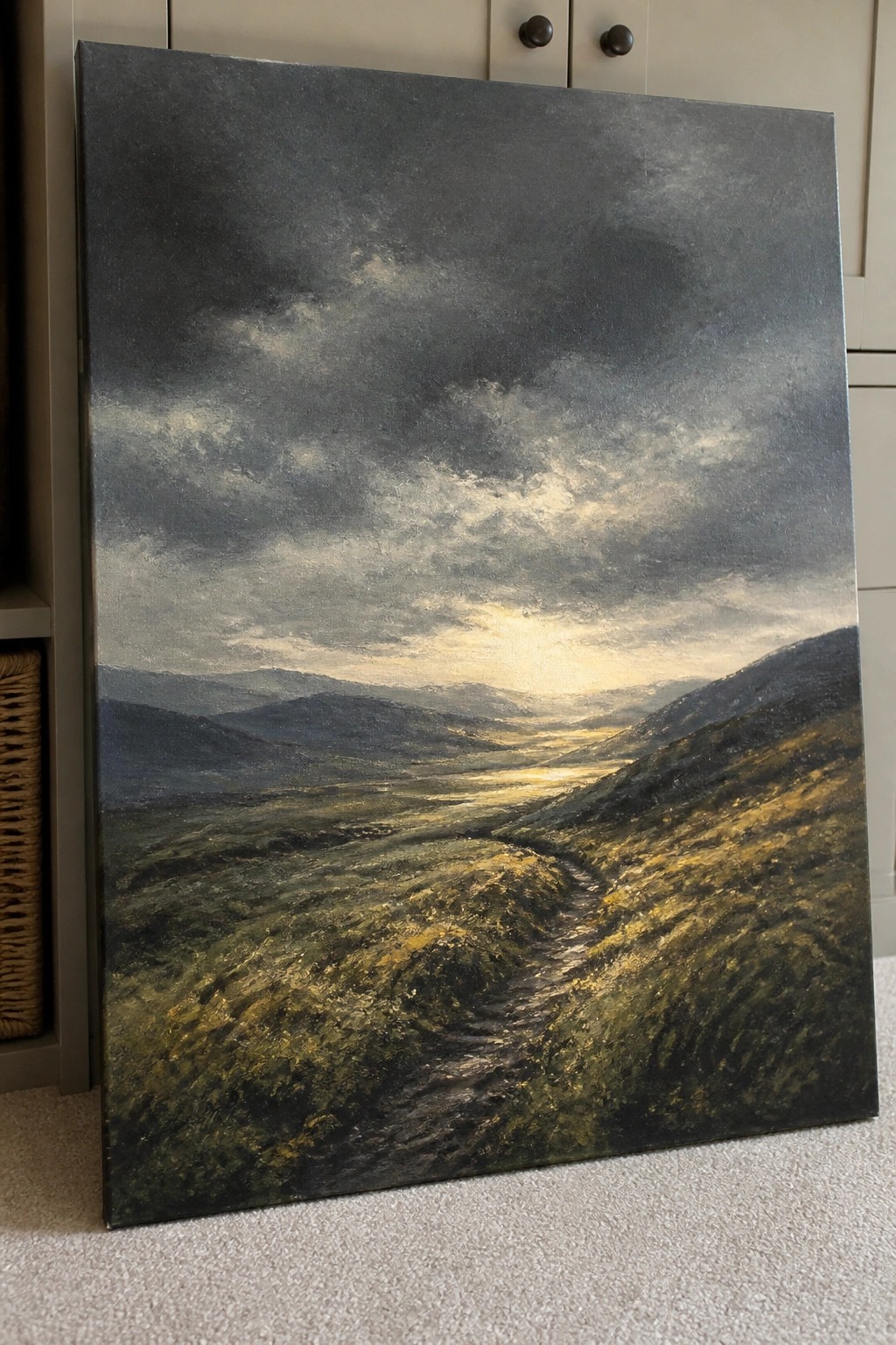Dramatic landscape painting of sunlit path winding through rolling hills under stormy skies