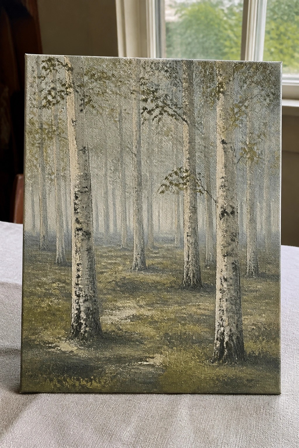 Misty forest painting with tall white birch trees on mossy ground in fog