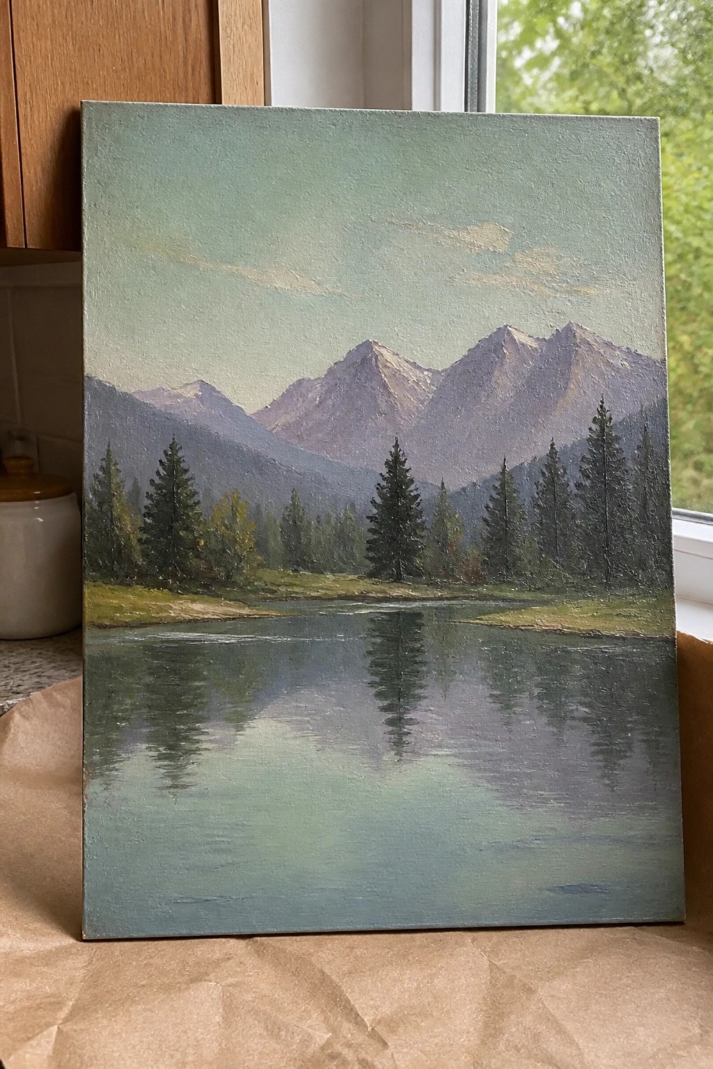 An oil painting of snow-capped mountains reflected in a calm lake with pine trees along the near shore.
