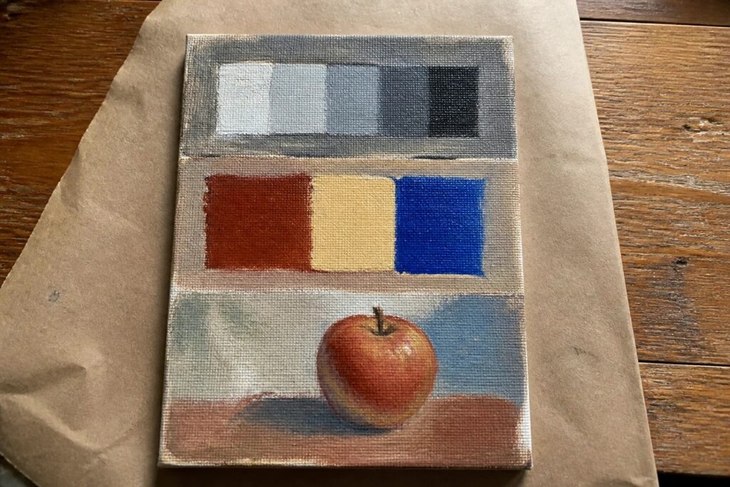 Still life painting of red apple below grayscale scale and color blocks on canvas