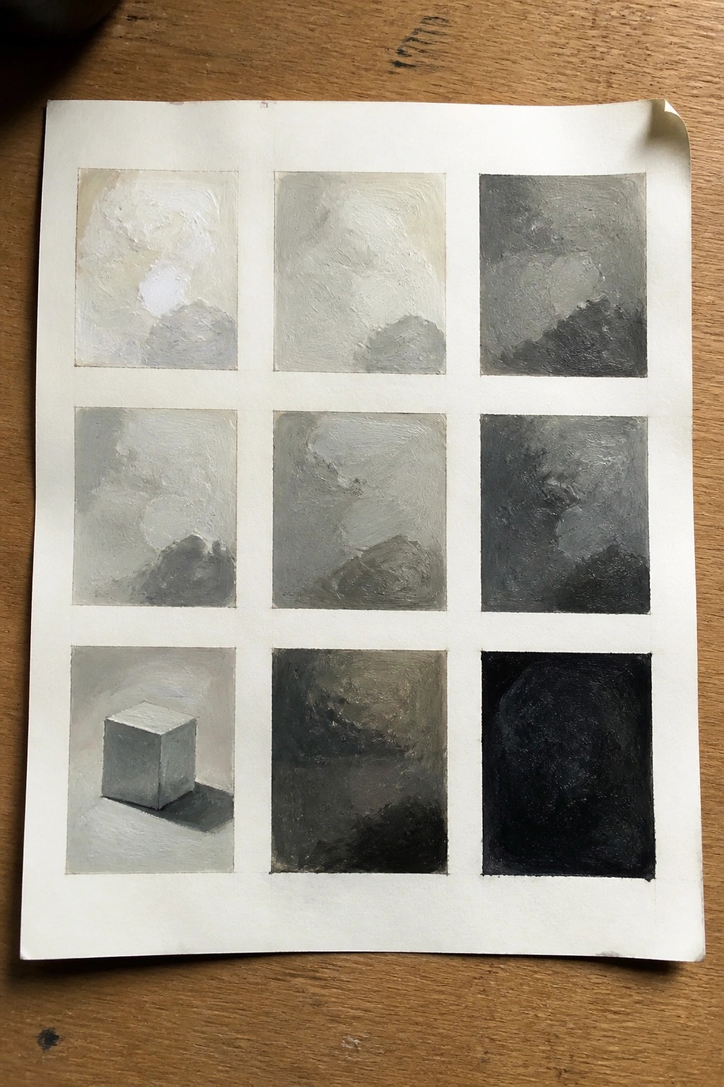 3x3 grid of grayscale tonal studies on paper, one showing a shaded cube