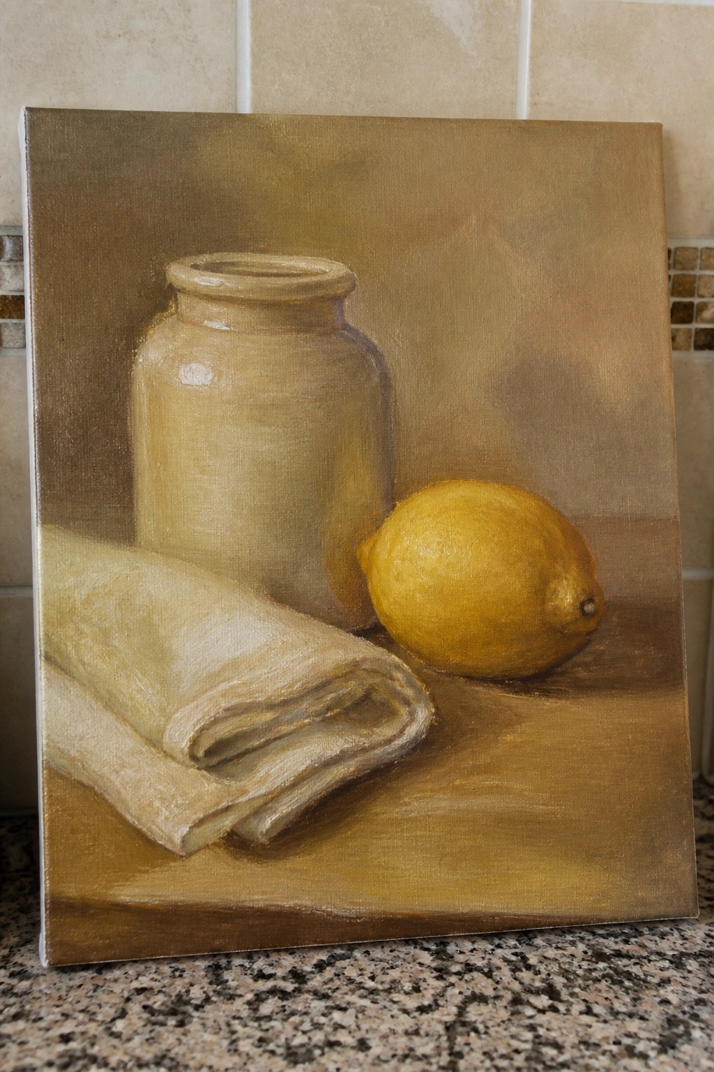 Still life painting of ceramic jar, yellow lemon, and folded cloth on brown table.