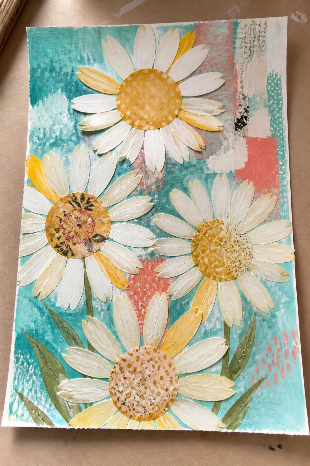 Three daisies with patterned centers in mixed-media collage on teal and coral background.