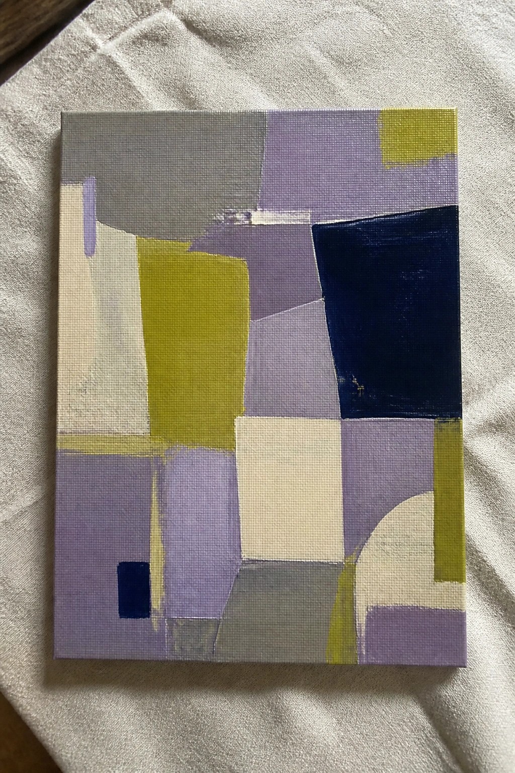 A rectangular oil painting on canvas featuring overlapping geometric shapes in shades of purple, gray, olive green, navy blue, and white.