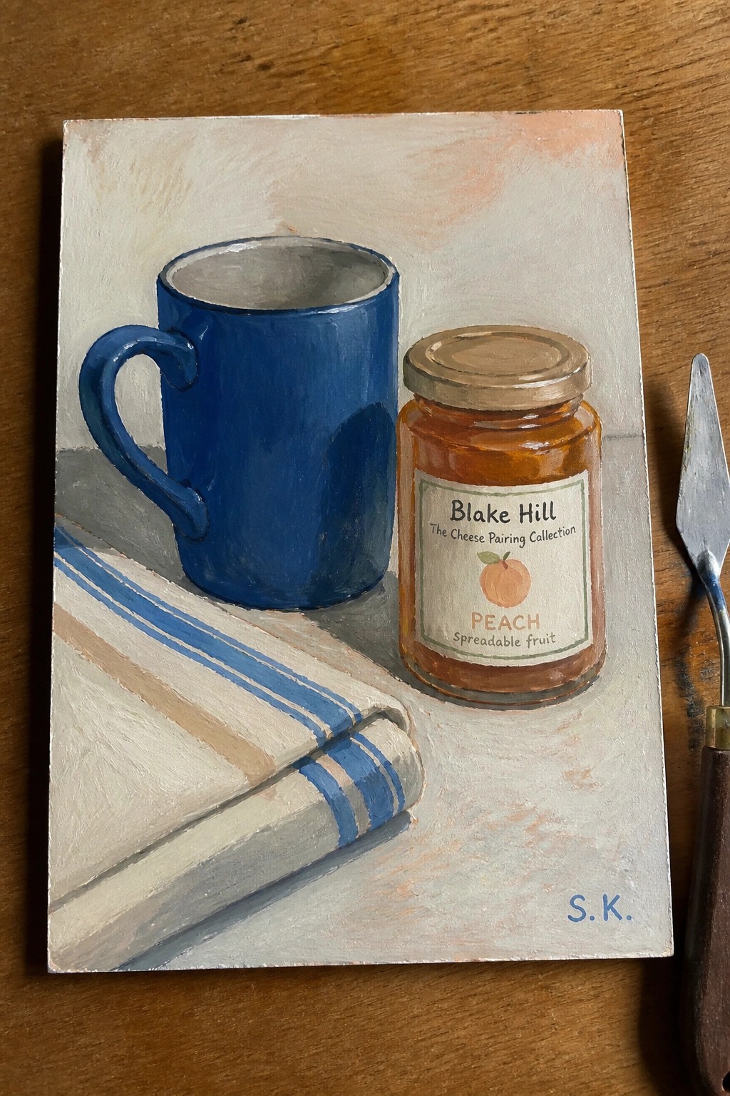 Still life painting of blue mug, peach jam jar, and striped cloth on table