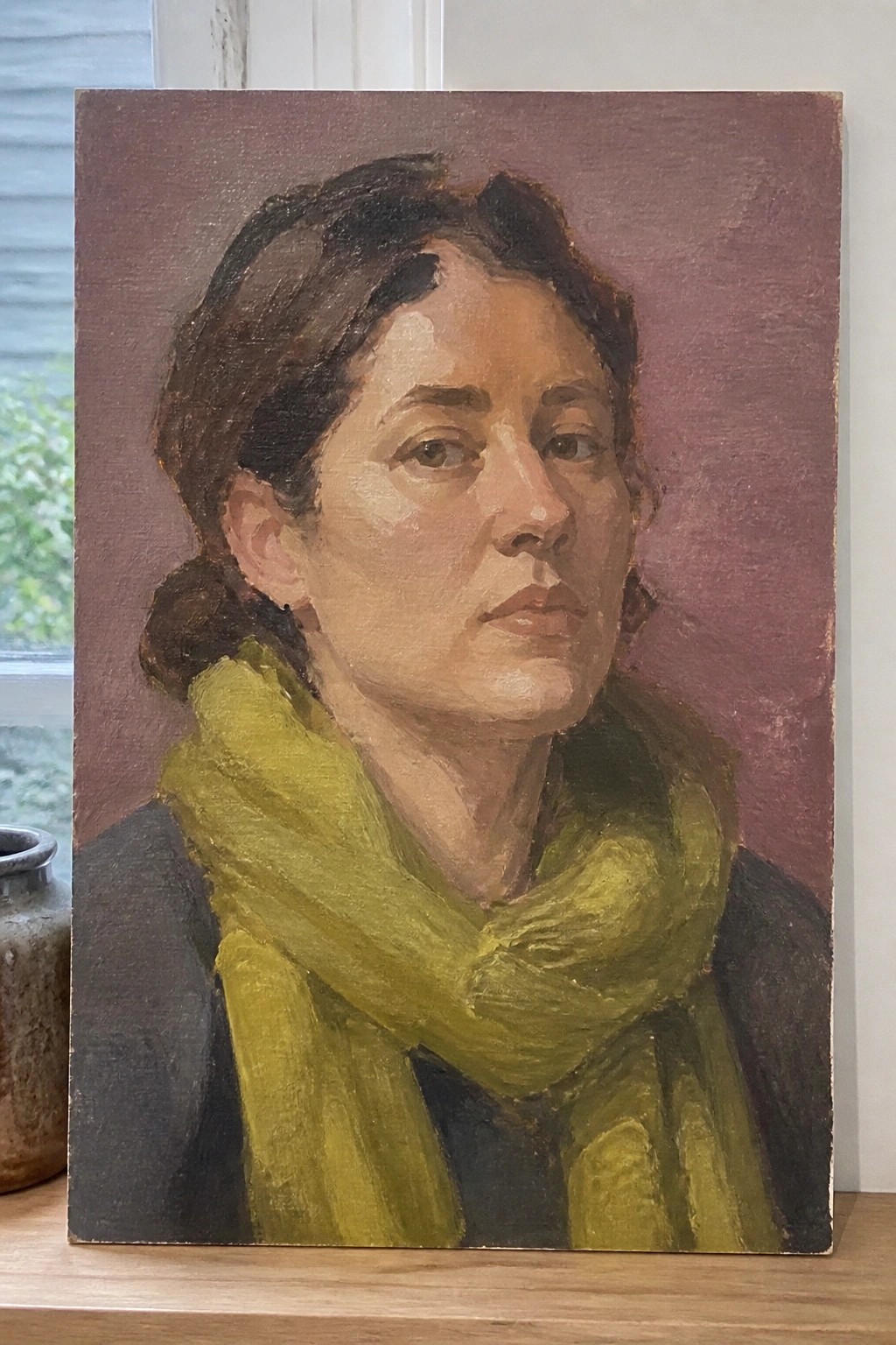 Oil portrait of woman with dark hair in yellow-green scarf against maroon background.