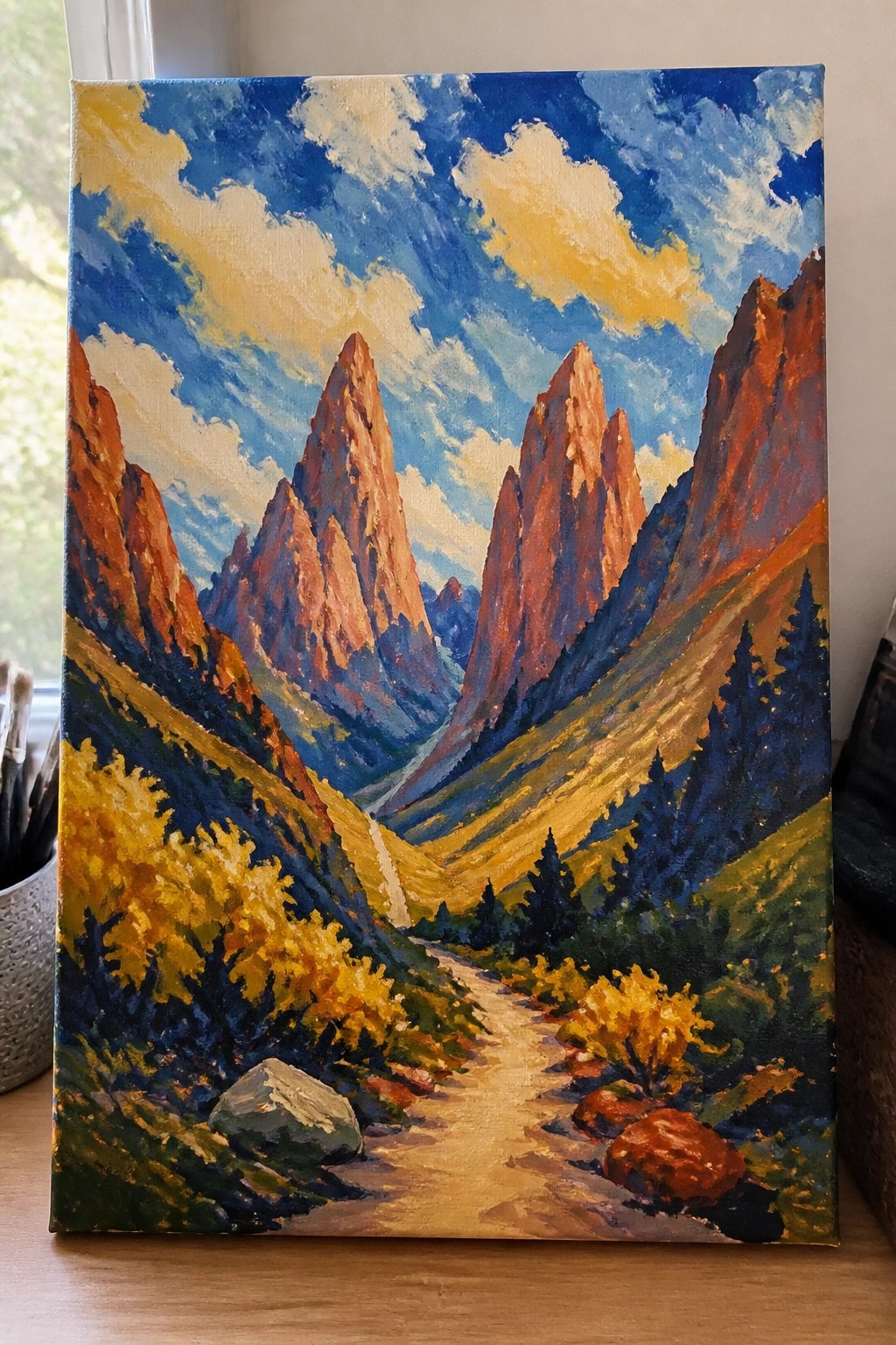 Vibrant painting of jagged red mountains, winding valley path, and golden autumn trees.