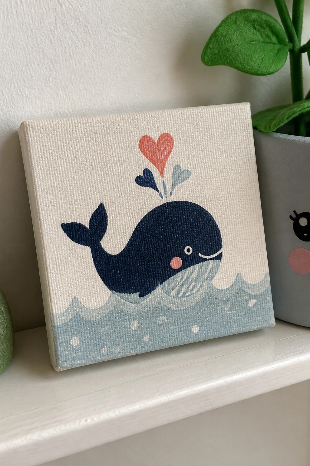 Canvas painting of smiling blue whale with red heart above light blue waves