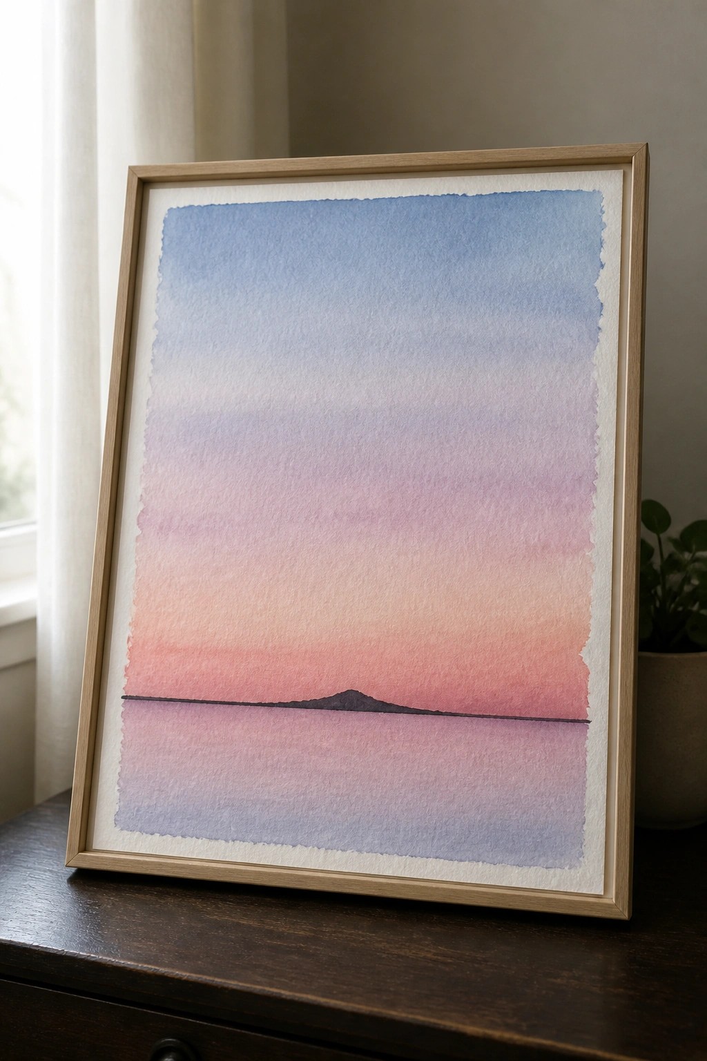Framed watercolor of gradient sunset sky with silhouetted island reflected on calm water