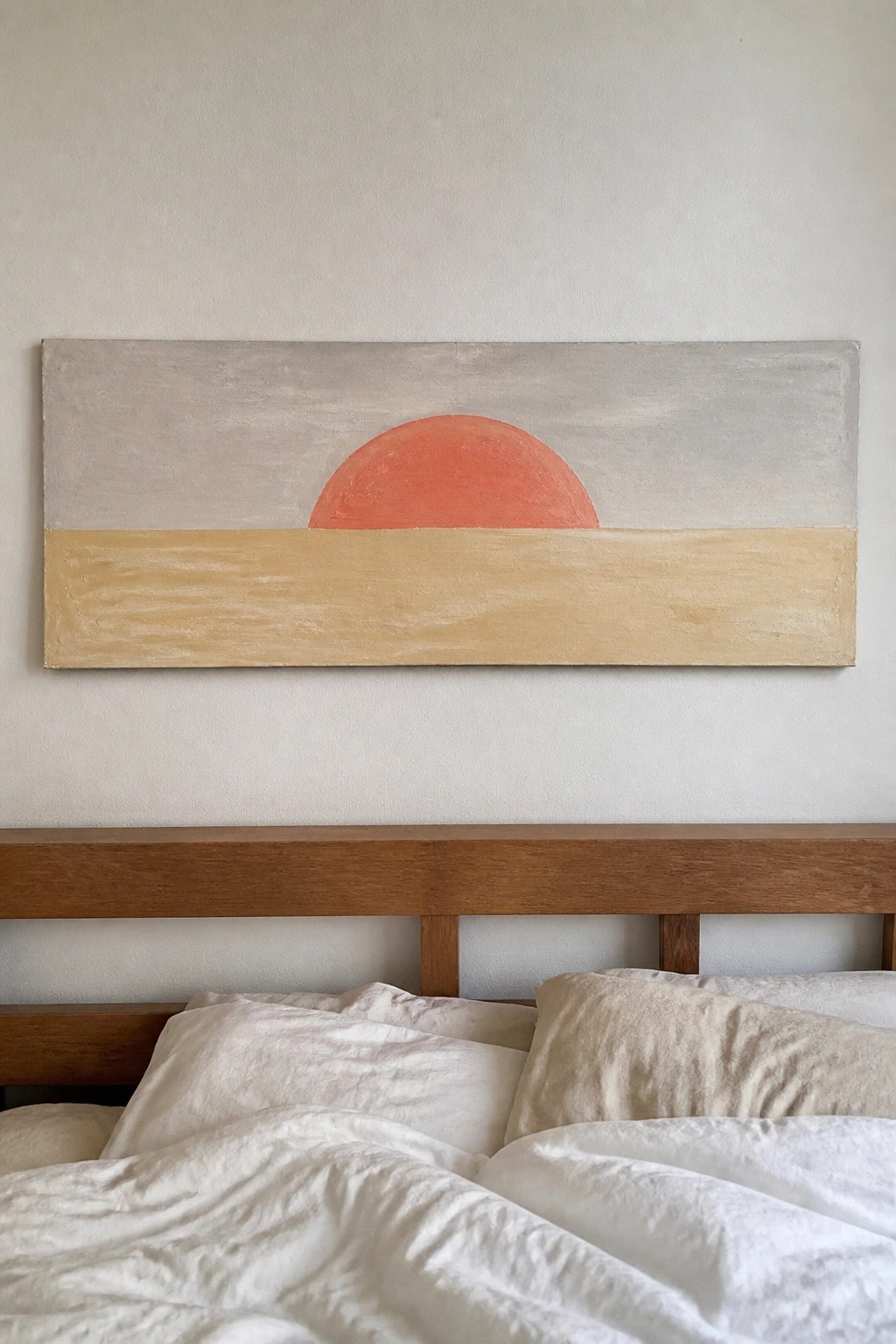 Minimalist painting of red sun over beige stripe above wooden bed with white linens