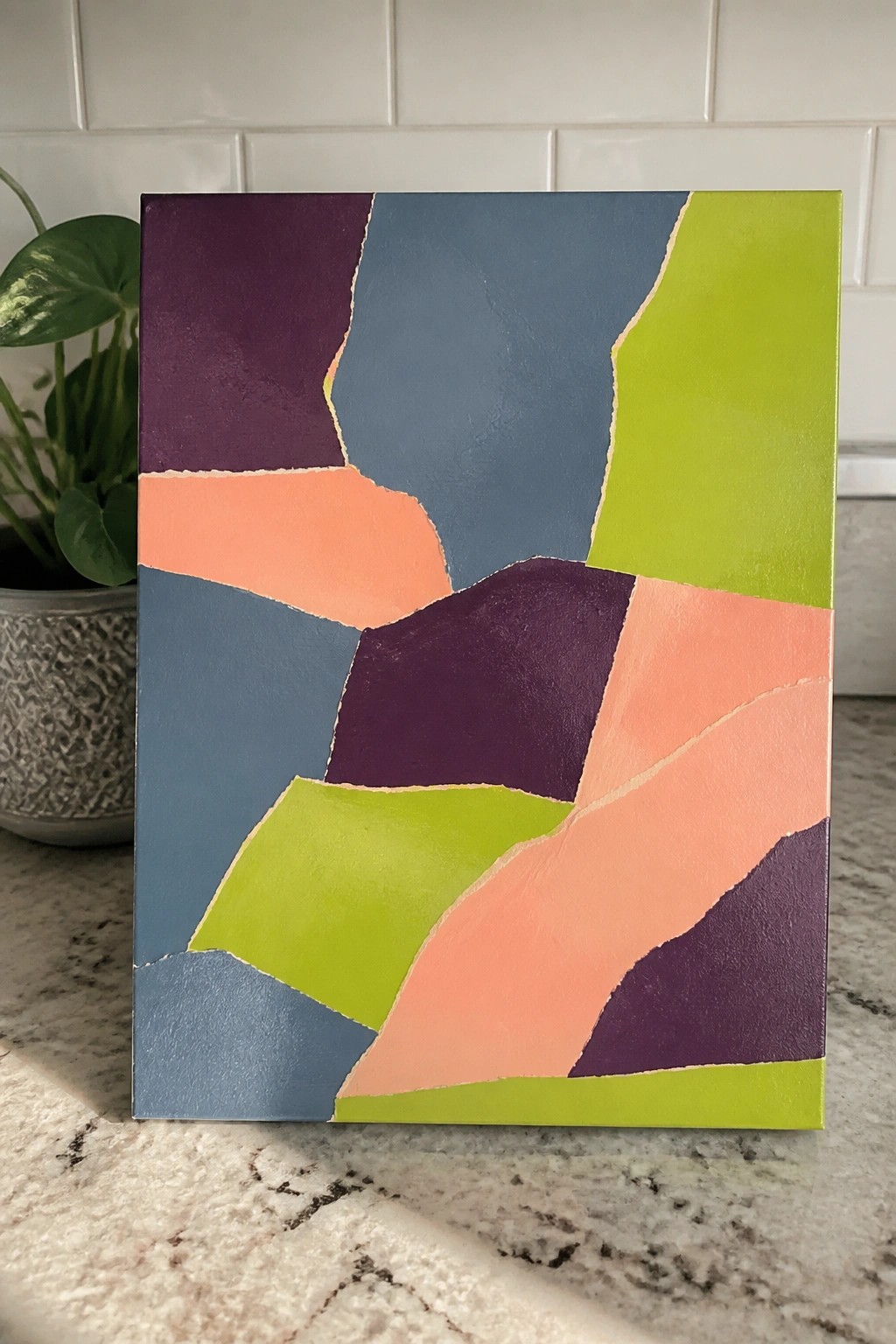 Abstract painting with irregular colorful shapes in purple, blue, green, and coral on canvas.